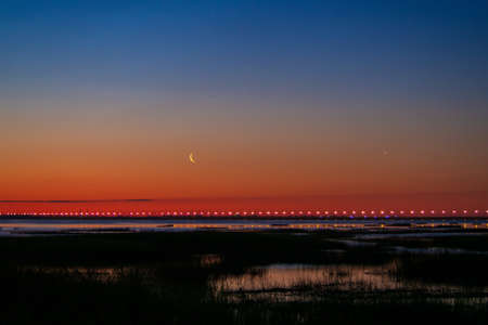 Sunset or sunrise with clouds. Red sunset and moon. beautiful sky. Prayer time. Generous Ramadan. Mubarak background.の写真素材