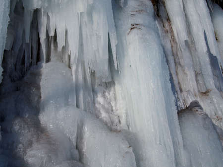 CLOSE UP Stunning frozen waterfall icicles on rocky mountain cliff on winter day.の写真素材