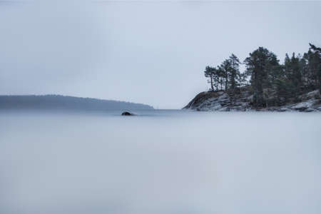 Lake Ladoga on a cloudy day. Stones and water are like fog. Long exposure.の写真素材
