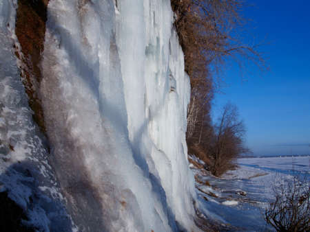CLOSE UP Stunning frozen waterfall icicles on rocky mountain cliff on winter day.の写真素材