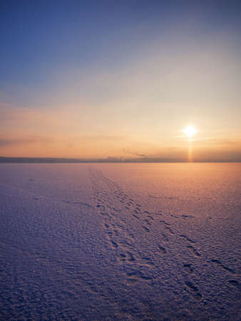 Sunset over a frozen and snow covered river on a winter morning. Winter sunset snow riverの写真素材