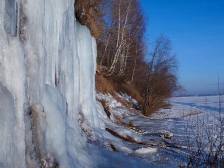 CLOSE UP Stunning frozen waterfall icicles on rocky mountain cliff on winter day.の写真素材