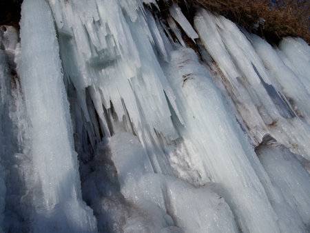 CLOSE UP Stunning frozen waterfall icicles on rocky mountain cliff on winter day.の写真素材