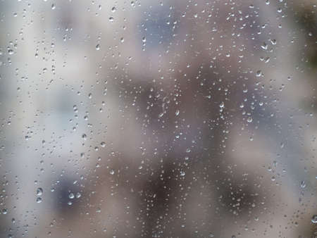 Raindrops on the surface of window glass with a blurred background.の写真素材