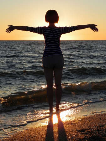 carefree woman dancing in the sunset on the beach. vacation vitality healthy living conceptの写真素材
