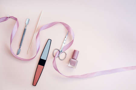 A set of cosmetic tools for manicure and pedicure on a pink background. Gel polishes, nail files, manicure scissors. photoの写真素材