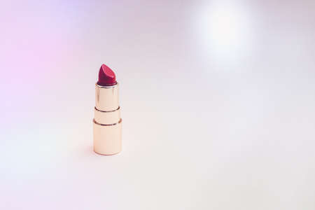 red lipstick in a gold case on a pink background. photoの写真素材