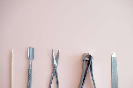 A set of cosmetic tools for manicure and pedicure on a pink background. Gel polishes, nail files, manicure scissors. photoの写真素材