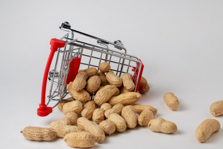 Peanuts in a nutshell in a shopping cart on a white background. photo