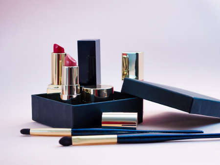 set of cosmetics for a female face and eye makeup in a black craft box on a pink background. photoの写真素材