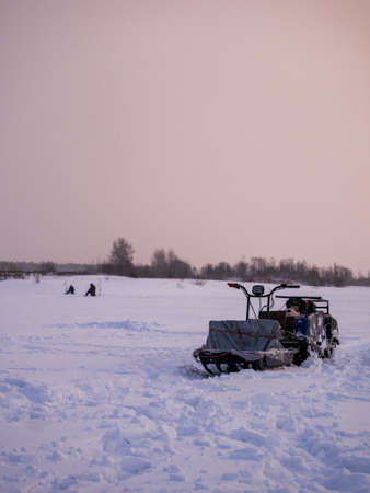 winter fishing. ice fishing. Fisherman, fishing on the ice. Electric snowmobile for fishing. Russiaの写真素材