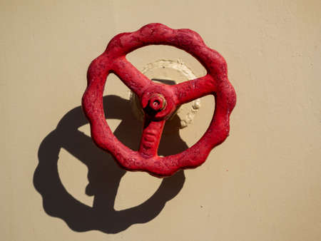 Close-up photo of a red valve against a beige wall of a nuclear icebreaker.の写真素材
