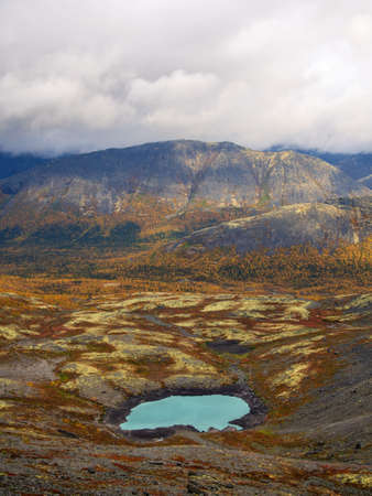 Lake with turquoise water in the mountains in autumn on a cloudy day. view from above. photoの写真素材