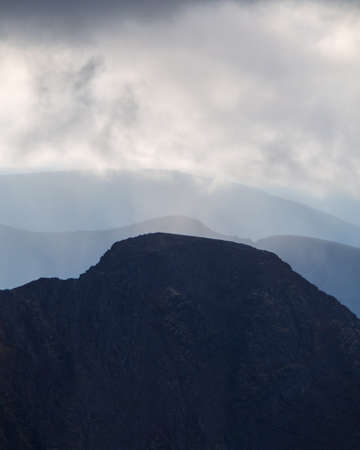 mountain peaks in the clouds. A chain of gray mountains in the backlight. Khibiny. photoの写真素材