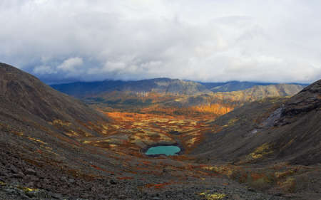 Lake with turquoise water in the mountains in autumn on a cloudy day. view from aboveの写真素材
