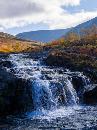 Beautiful mountain waterfall among rocks in polar summer in Khibiny Mountains. Kola Peninsula, Arctic, polar summerの写真素材