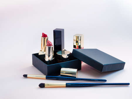 set of cosmetics for a female face and eye makeup in a black craft box on a pink background. photoの写真素材