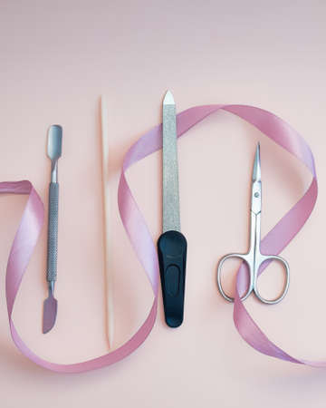 A set of cosmetic tools for manicure and pedicure on a pink background. Gel polishes, nail files, manicure scissors. photoの写真素材