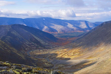Autumn colorful tundra on the background mountain peaks in cloudy weather. Mountain landscape in Kola Peninsula, Arctic, Khibiny Mountains.の写真素材