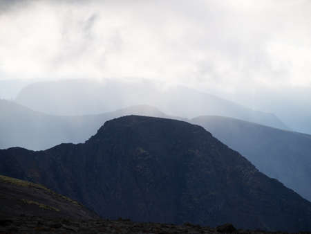 Mountain peaks in the clouds. A chain of gray mountains in the backlight. Khibinyの写真素材