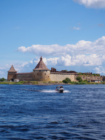 A stunning fortress stands proudly on the edge of a serene lake, with a small boat speeding across...