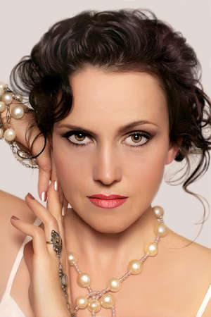 Portrait of beautiful young woman with Beads on a light backgroundの写真素材