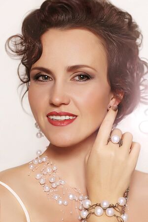 Portrait of beautiful young woman with Beads on a light backgroundの写真素材
