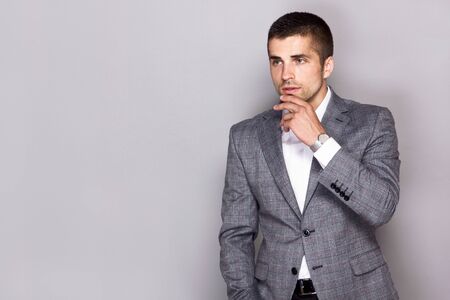 handsome young man wears a watch in a business suitの写真素材