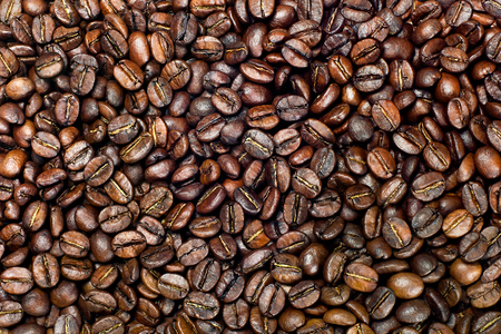fried golden coffee beans background, close upの写真素材