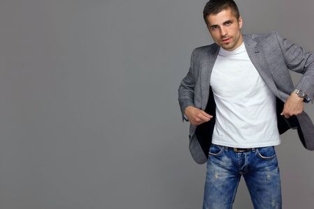 Model man brandishing a gray jacket on a gray background, studioの写真素材