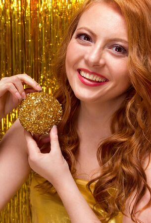 Girl model on a yellow background in a gold dressの写真素材