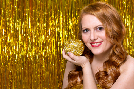 Girl model on a yellow background in a gold dressの写真素材