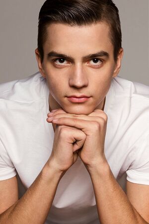 a young man in a white T-shirt model studio portraitの写真素材