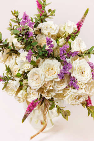 a bouquet of white roses in a vase on the tableの写真素材