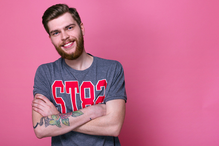 a young man with a beard in a shirt on a bright backgroundの写真素材