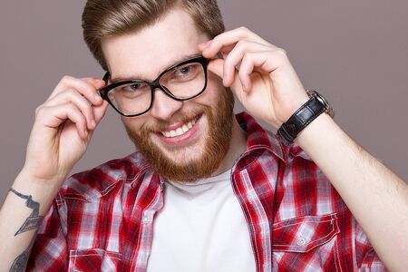 Model man in a plaid shirt and glasses smiles with a beardの写真素材