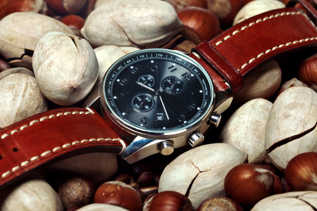 men's watch close up lying flat on the nutsの写真素材