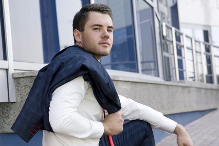 Male model sitting happily on the building backgroundの写真素材