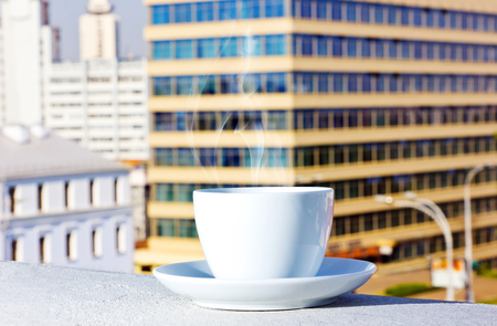 on the background of buildings on the balcony with a cup of tea, coffeeの写真素材