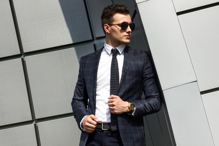 fashionable young man dressed in the gray background beautiful urban architectural formの写真素材