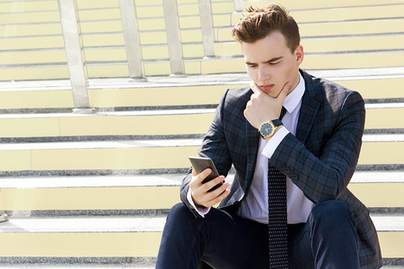 male model sitting on the stairs in a suitの写真素材