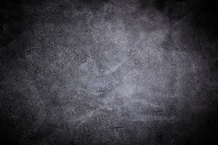 black wall covered with a layer of uneven rough plasterの写真素材