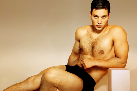 Male athlete in shorts sitting studioの写真素材