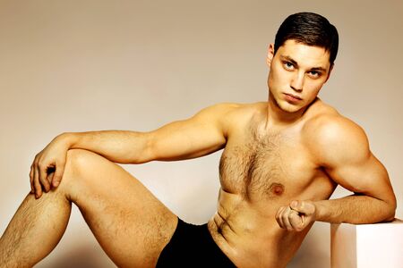 Male athlete in shorts sitting studioの写真素材