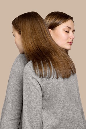 art portrait of young beautiful woman. two girls in one effectの写真素材