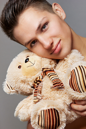 A guy with a little teddy bearの写真素材
