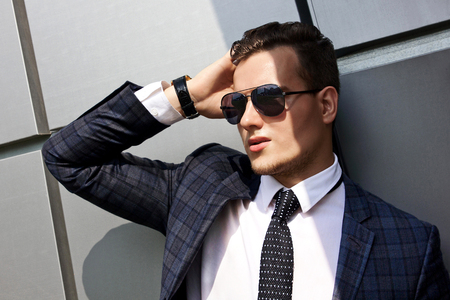 fashionable young man dressed in the gray background beautiful urban architectural formの写真素材