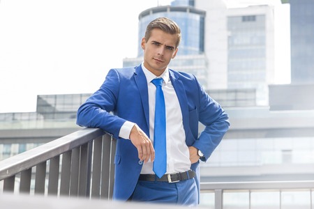 Stylish man posing against the background of a modern buildingの写真素材