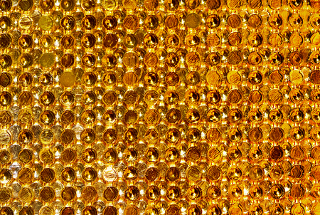 textured golden background of small golden circlesの写真素材