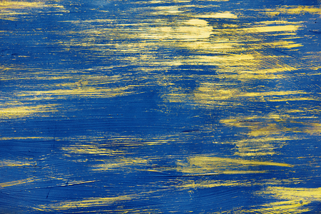 The smears of blue and gold paint are randomly scattered over the backgroundの写真素材